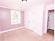 This is a bedroom with light purple walls, a white door, and a light-colored carpet at 5020 Foster Rd, Cleveland, NC 27013