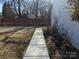 Sidewalk next to a house with a wooden fence and shrubs at 5938 Trysting Rd, Charlotte, NC 28227