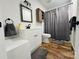 Clean bathroom with white vanity, shower, and wood-look floors at 813 S Zion St, Landis, NC 28088