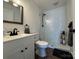 Modern bathroom with white vanity, shower, and wood-look floors at 813 S Zion St, Landis, NC 28088
