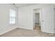 Cozy bedroom with neutral walls, carpet flooring, and a door to hallway at 8436 Dawson Ln, Locust, NC 28097