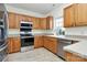 Spacious kitchen with wood cabinets, stainless steel appliances, and tile floor at 8436 Dawson Ln, Locust, NC 28097
