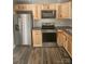 Stainless steel appliances and wood cabinets in updated kitchen at 104 Rice St, Kannapolis, NC 28081