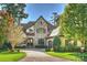 Exterior of a stunning stone house with a large driveway and lush landscaping at 1105 Hadley Park Ln, Weddington, NC 28104