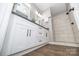 Modern bathroom features white cabinets, dark countertops, and a walk-in shower with neutral tile at 117 Chavis Ln, Lincolnton, NC 28092