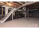 Unfinished basement with exposed beams, stairs, and painted brick at 2504 S Cannon Blvd, Kannapolis, NC 28083