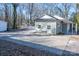 View of house, garage, and new gravel area with a white picket fence in the background at 2504 S Cannon Blvd, Kannapolis, NC 28083