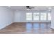Open living room space featuring paneled walls, three windows, and hardwood floors at 2504 S Cannon Blvd, Kannapolis, NC 28083