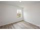 Bright bedroom with wood-look floors and a window offering natural light at 3012 Sadler Woods Ln, Charlotte, NC 28214