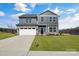 Two-story gray house with white garage and landscaped lawn at 3025 Swallowtail Ln, Kannapolis, NC 28083