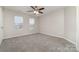 Simple bedroom with gray carpet and two windows at 5110 Osage Cir, Charlotte, NC 28269
