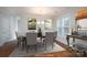 Virtually staged dining room with hardwood floors and large windows at 9451 Bonnie Briar Cir, Charlotte, NC 28277