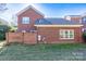 Rear view of brick house, showing a wall and landscaping at 9451 Bonnie Briar Cir, Charlotte, NC 28277