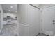 White laundry room with built-in shelving and tile floor at 9451 Bonnie Briar Cir, Charlotte, NC 28277