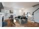 Virtually staged living room with hardwood floors, fireplace, and stairs at 9451 Bonnie Briar Cir, Charlotte, NC 28277