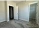 Well-lit bedroom featuring carpet, an attached closet, and access to the hallway at 1225 E 34Th St # Csw0419, Charlotte, NC 28205