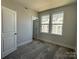 Spacious bedroom with carpet, double windows, and a door leading to the hallway at 1225 E 34Th St # Csw0419, Charlotte, NC 28205