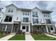 Modern townhomes featuring brick and white siding, balconies, and well-maintained landscaping in a vibrant community at 1225 E 34Th St # Csw0419, Charlotte, NC 28205