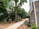 Scenic view along sidewalk lined by lush trees and bushes, beside brick townhomes for a peaceful, natural setting at 1225 E 34Th St # Csw0419, Charlotte, NC 28205