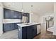 Modern kitchen features navy cabinets, stainless appliances, quartz countertops, and an island with sink at 1227 E 34Th St # Csw0420, Charlotte, NC 28205