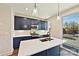 Modern kitchen boasts navy blue cabinetry, stainless steel appliances, quartz countertops, an island, and sleek pendant lighting at 1227 E 34Th St # Csw0420, Charlotte, NC 28205