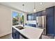 Bright kitchen featuring navy blue cabinetry, stainless steel appliances, an island with a quartz countertop, and modern pendant lights at 1227 E 34Th St # Csw0420, Charlotte, NC 28205