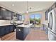 Contemporary kitchen with navy blue cabinets, stainless steel appliances, a center island, and a large sliding glass window at 1227 E 34Th St # Csw0420, Charlotte, NC 28205