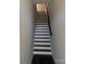 A clean, modern staircase with dark wood treads, white risers, and a dark handrail, leading to the upper floor at 1227 E 34Th St # Csw0420, Charlotte, NC 28205