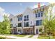 Newly constructed townhomes feature brick accents, white siding, black balconies, and beautifully landscaped grounds at 1229 E 34Th St # Csw0421, Charlotte, NC 28205
