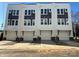 Exterior of new townhouses featuring white garage doors, charcoal accents and light colored brick foundations at 1229 E 34Th St # Csw0421, Charlotte, NC 28205