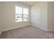 Bright bedroom with a window overlooking the neighborhood, carpet flooring, and base molding at 3111 Vermillion Dr, Harrisburg, NC 28075