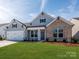 Charming single-Gathering home featuring a two-car garage, brick facade, and manicured lawn at 3111 Vermillion Dr, Harrisburg, NC 28075