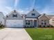 Charming home with a two-car garage, manicured lawn, and a blend of siding and brick exterior accents at 3111 Vermillion Dr, Harrisburg, NC 28075
