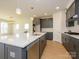 Kitchen featuring white quartz counters, gray cabinets with gold hardware, and a stainless dishwasher at 3111 Vermillion Dr, Harrisburg, NC 28075
