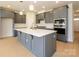 Kitchen with gray cabinets, a large island, stainless steel appliances, and hardwood floors at 3111 Vermillion Dr, Harrisburg, NC 28075