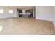 Light wood flooring leading to an open kitchen with a center island and modern appliances at 3111 Vermillion Dr, Harrisburg, NC 28075