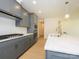 Kitchen features white quartz counters, gray cabinets with gold hardware, and a gas cooktop at 3111 Vermillion Dr, Harrisburg, NC 28075