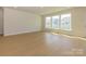 Spacious room features light wood flooring, three large windows and an exterior door at 3111 Vermillion Dr, Harrisburg, NC 28075