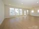 Large, open space with wood flooring, a modern light fixture, and plenty of natural light at 3111 Vermillion Dr, Harrisburg, NC 28075