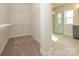 Spacious walk-in closet with carpet flooring, wire shelving, and a view of the primary bathroom at 3111 Vermillion Dr, Harrisburg, NC 28075