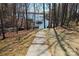 Stone walkway leading to a serene lake view surrounded by mature trees and natural landscaping at 3830 Mill Run, Terrell, NC 28682