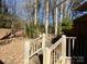 Wooden deck steps leading to a wooded backyard at 5514 Grafton Pl, Charlotte, NC 28212