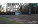 White outbuilding nestled amongst mature trees in a wooded setting at 6726 Lockhart Rd, Sharon, SC 29742