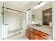 Clean bathroom featuring a glass-enclosed shower, granite vanity, and a window for natural light at 9809 Saddle Ave, Waxhaw, NC 28173