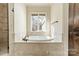 Luxurious bathroom with a soaking tub and travertine tile at 9809 Saddle Ave, Waxhaw, NC 28173