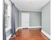 Simple bedroom with hardwood floors, window, and gray curtains at 106 Patrick St, Gastonia, NC 28054