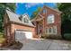 Brick two-story house with a three-car garage and landscaping at 10843 Alexander Mill Dr, Charlotte, NC 28277