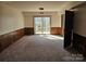 A spacious basement with paneled walls and large sliding glass doors leading to the backyard, perfect for recreation at 1608 Carfax Dr, Charlotte, NC 28216