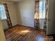 Cozy bedroom with hardwood floors, large windows, and decorative curtains at 1608 Carfax Dr, Charlotte, NC 28216