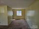 A cozy living room with neutral walls and carpet, perfect for relaxing or entertaining guests at 1608 Carfax Dr, Charlotte, NC 28216